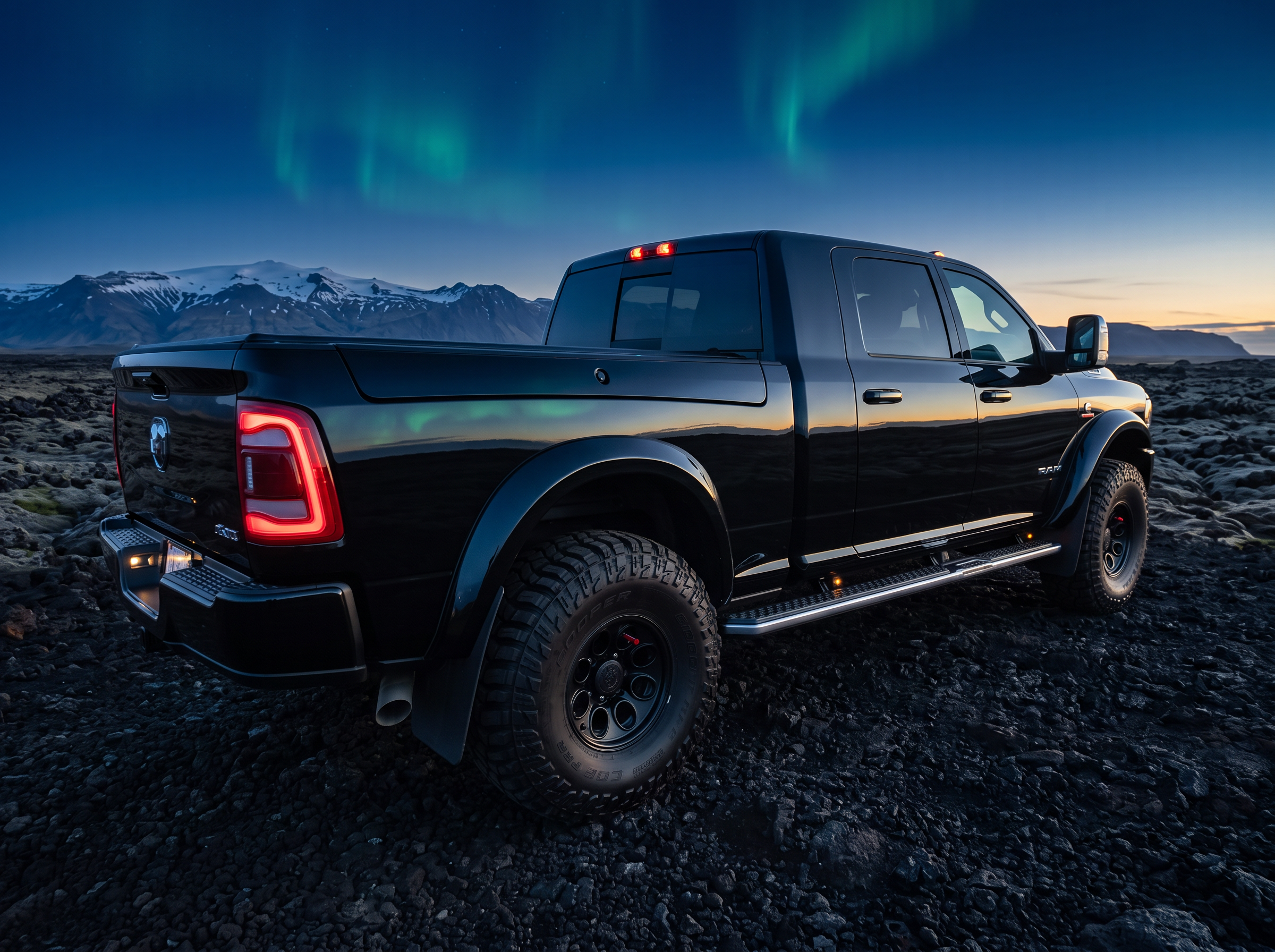 Side view of the black RAM 3500 on a lava field beneath the northern lights